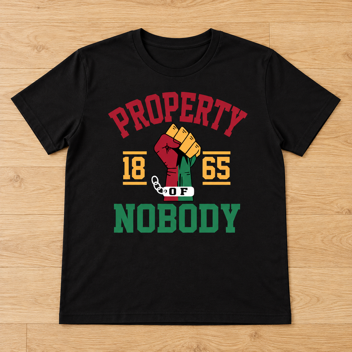 Black Property of Nobody Since 1865 Tee laid flat on light wood