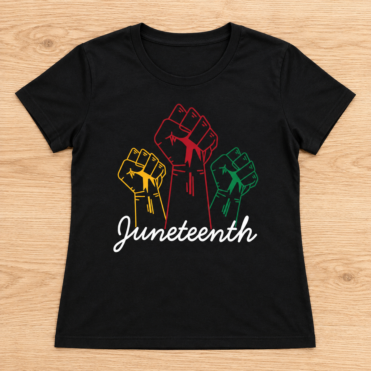 Black Juneteenth Freedom — Three Fists Tee laid flat on light wood