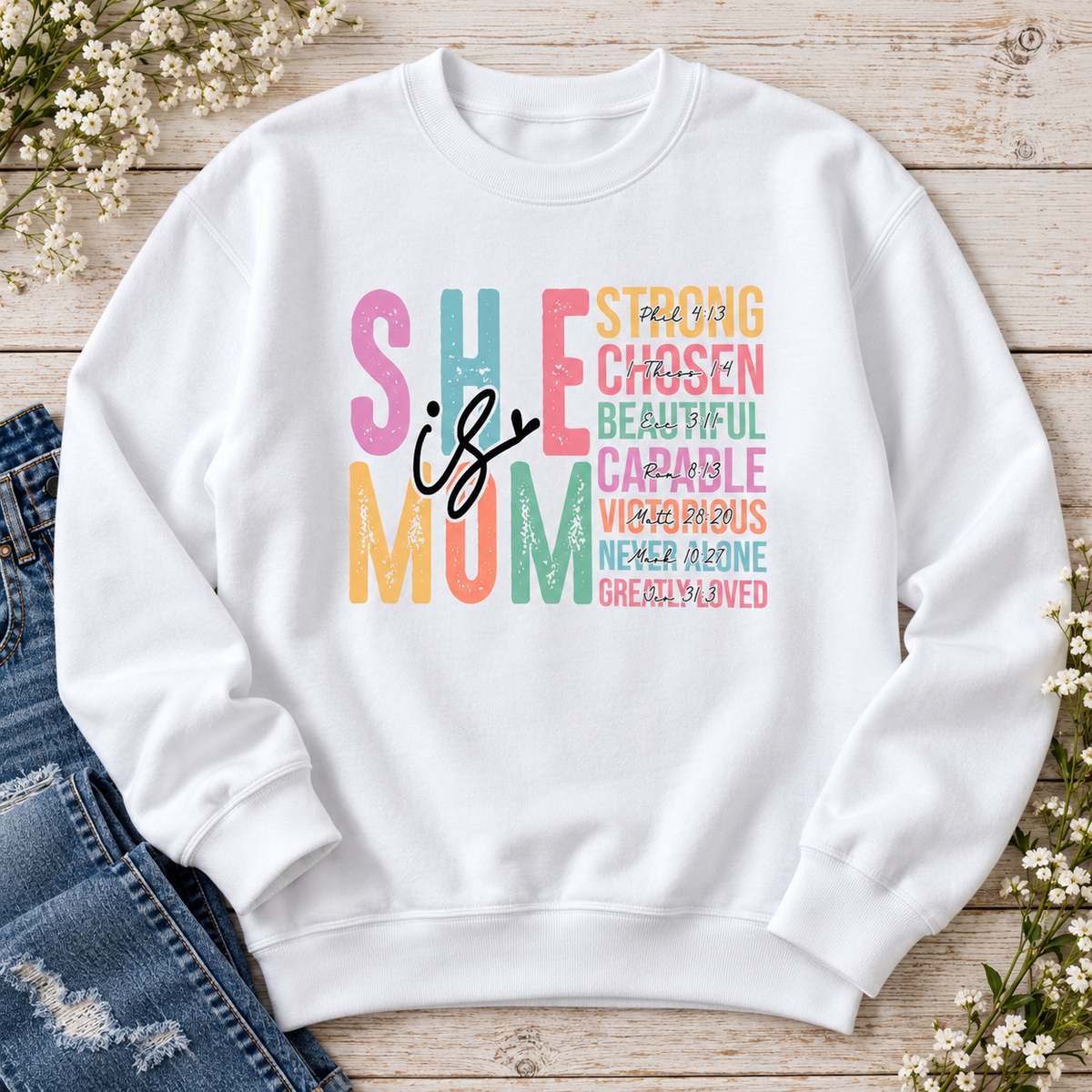 She Is Mom Crewneck Sweatshirt — styled flat lay showing the front design